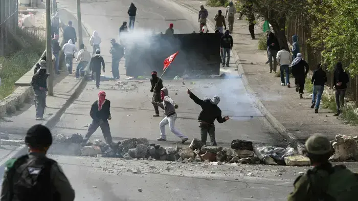 חייל מג"ב ישראלי יורה גז מדמיע לעבר פלסטינים במזרח ירושלים