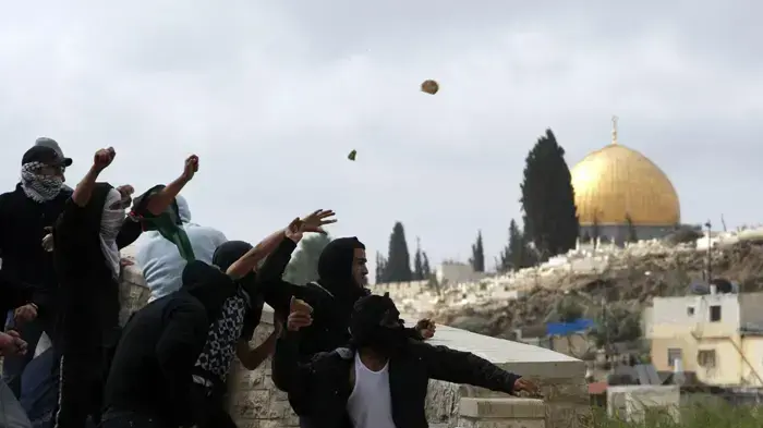 פלסטינים במזרח ירושלים זורקים אבנים  במהלך יום הזעם