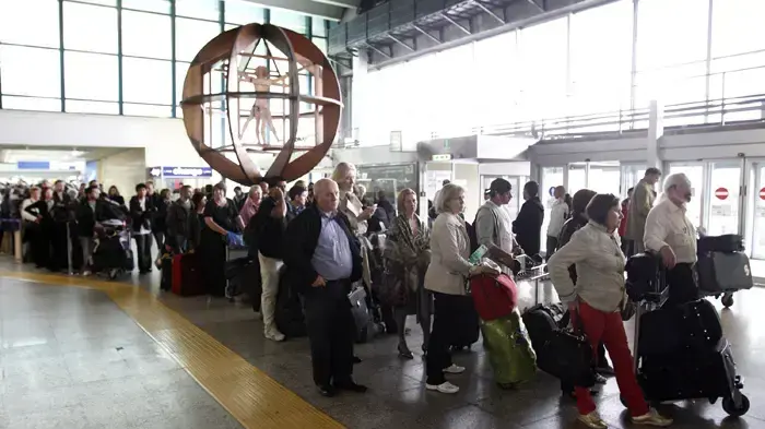 נוסעים עומדים בתור בשדה התעופה ברומא, איטליה