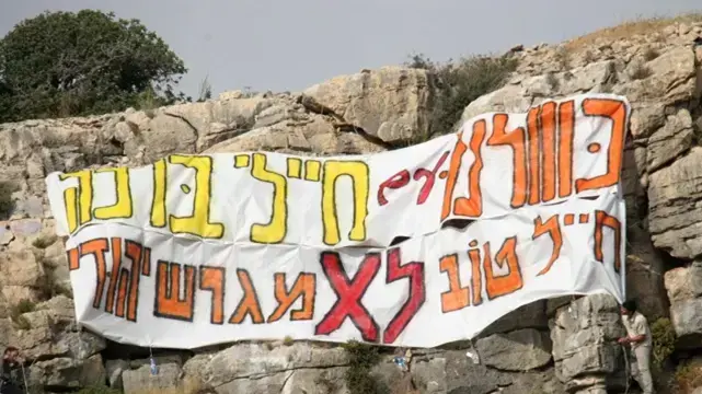 כרזה שנתלתה מעל כלא 6 התומכת בחיילים המסרבים לפנות יישובים