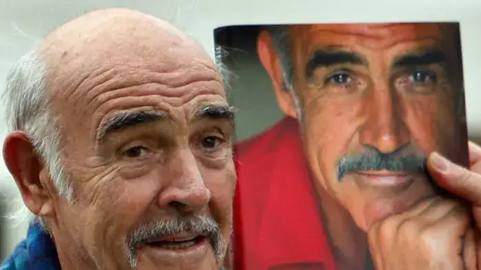 שון קונרי עם עותק מהביוגרפיה שלו