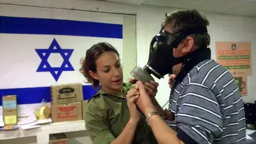 חיילת מסבירה לאזרח איך לשים מסיכת אב"כ, 1991