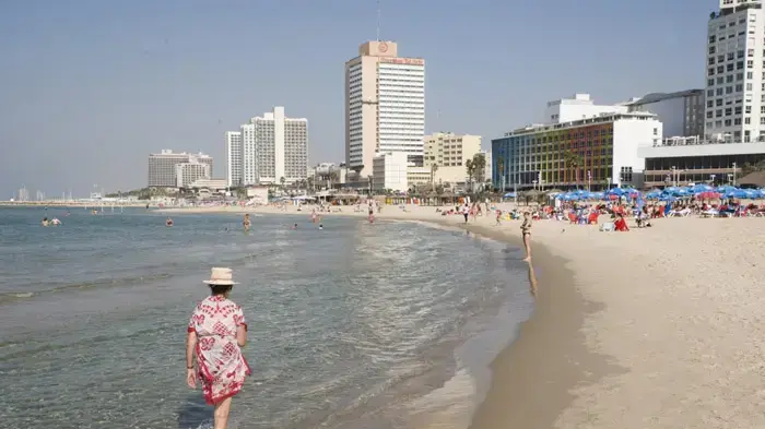 אנשים מבלים בחופי תל אביב, בשרב באמצע נובמבר