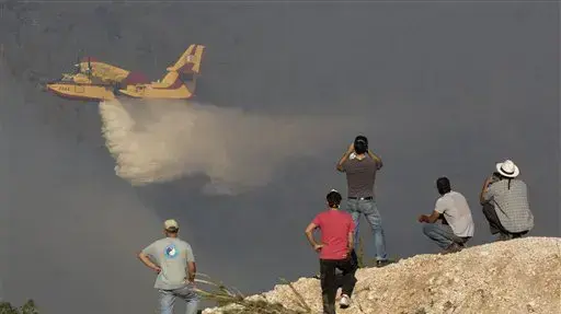 סקרנים צופים במטוס כיבוי מעל עין הוד