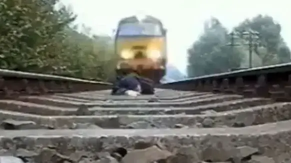 אדם נשכב מתחת לרכבת נוסעת
