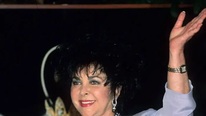 אליזבת טיילור בעת השקת הבושם Black Pearls בסניף מייסיס בניו יורק, פברואר 1989 אליזבת טיילור בעת השקת הבושם Black Pearls בסניף מייסיס בניו יורק, פברואר 1989