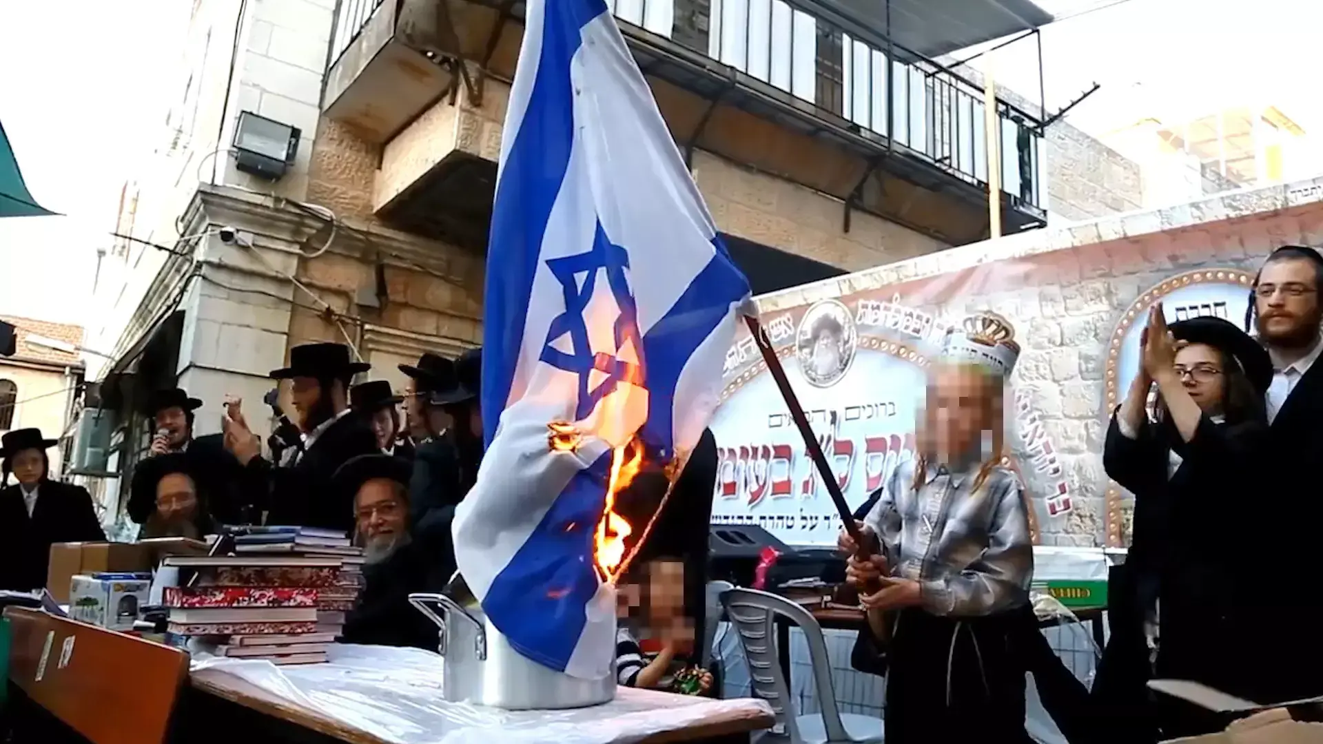 ילד חרדי שרף דגל ישראל בחגיגות ל"ג בעומר של חרדים קיצונים