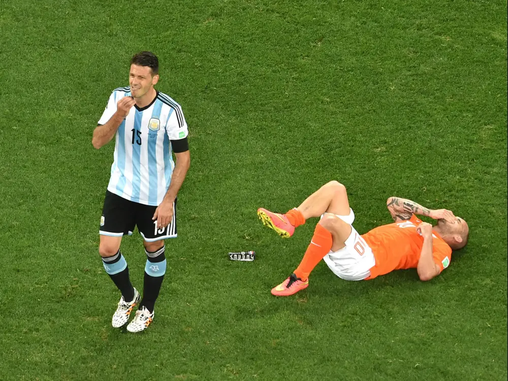 שחקן נבחרת הולנד ווסלי סניידר על הדשא, לצידו שחקן נבחרת ארגנטינה מרטין דמיצ'ליס