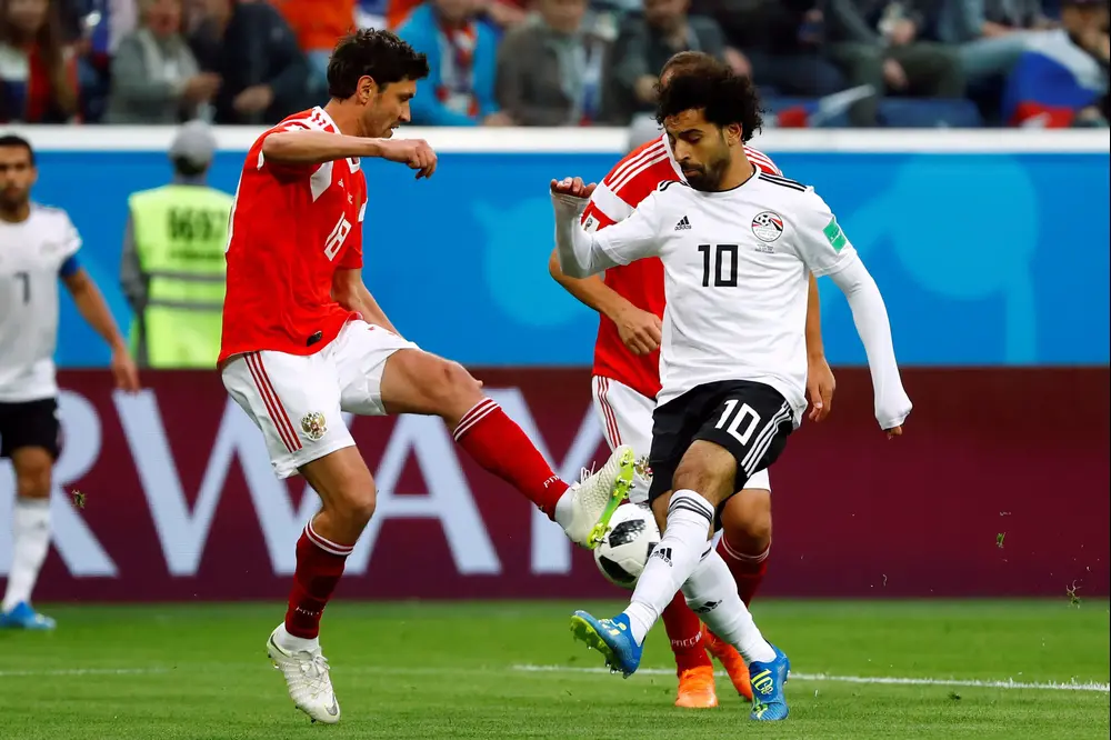 שחקן נבחרת מצרים, מוחמד סלאח, מול שחקן נבחרת רוסיה, יורי ז'ירקוב