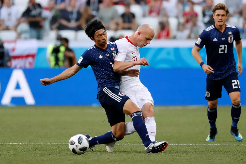 שחקן נבחרת יפן גאקו שיבסאקי עם שחקן נבחרת פולין רפאל קורזאבה