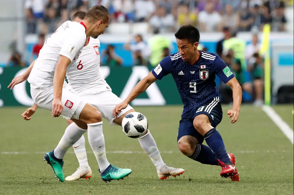 שחקן נבחרת יפן שינג'י אוקזאקי עם שחקני נבחרת פולין