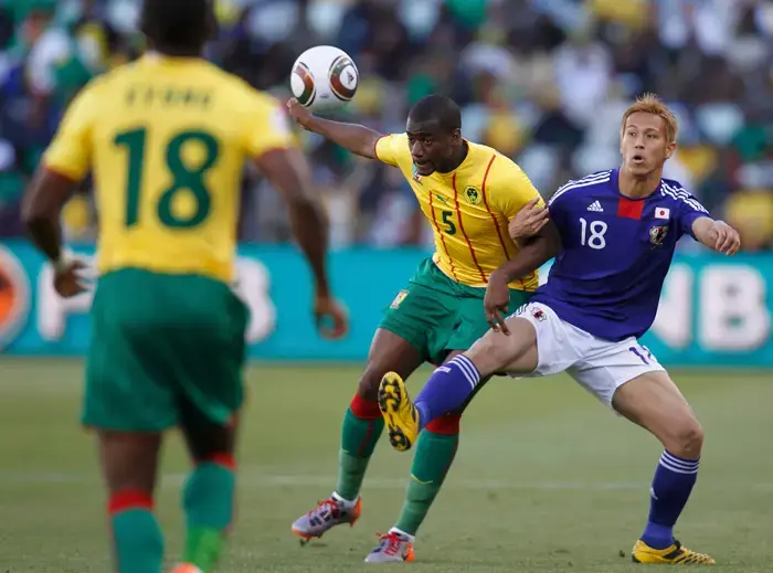 קייסוקה הונדה (ימין) שחקן יפן מול פייר וובו שחקן קמרון