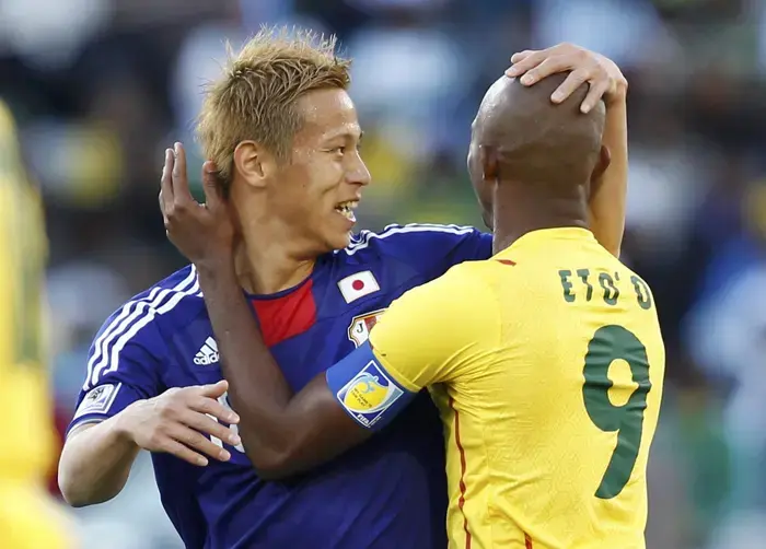 סמואל אטו, נבחרת קמרון, מתחבק עם קייסוקה הונדה, נבחרת יפן