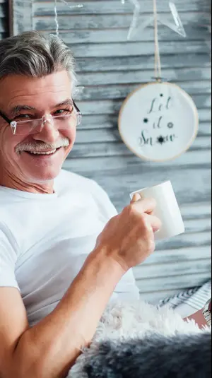 איש מבוגר עם כוס תה קורא ספר. ShutterStock