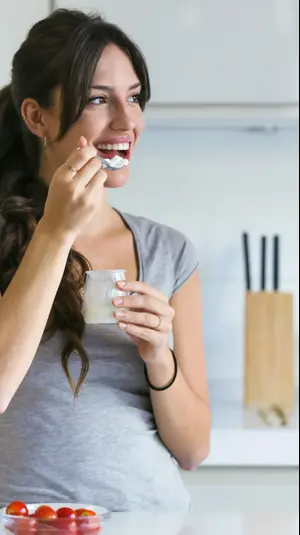אישה אוכלת יוגורט. ShutterStock