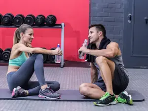 גבר ואישה שותים מים אחרי אימון כושר (ShutterStock)