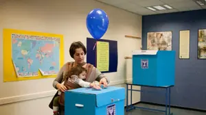 מצביעה עם בתה בקלפי בתל אביב, ינואר 2013 (AP)