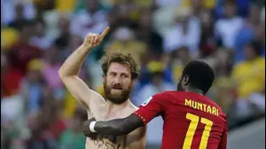 שחקן גאנה סולי מונטארי מוציא אוהד שבפרץ למגרש במשחק בין נבחרת גאנה לנבחרת גרמניה (AP)