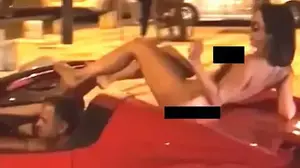 נהג בפרארי עם אישה עירומה מעליו (צילום מסך)