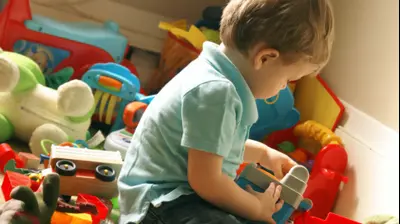 ילד משחק בצעצועים בחדר מבולגן (ShutterStock)