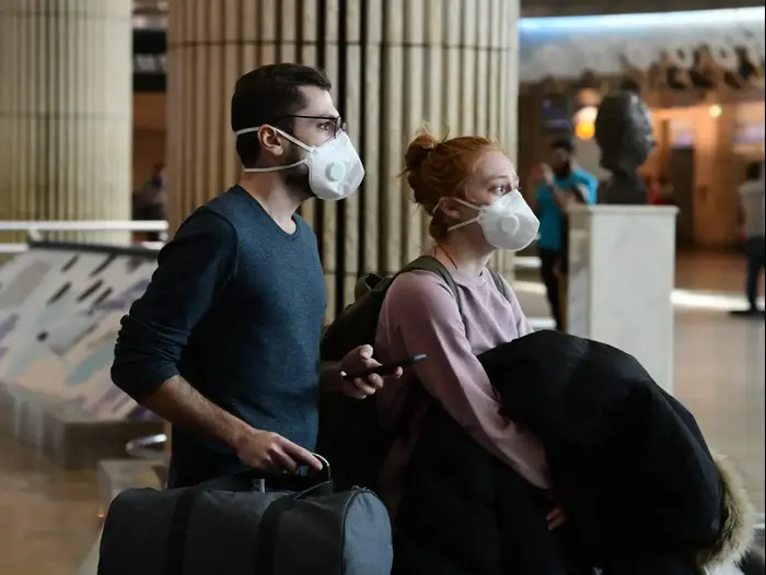 נוסעים מתגוננים עם מסכה מנגיף הקורונה בשדה התעופה בן גוריון 10 במרץ 2020 (ראובן קסטרו)