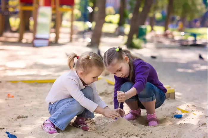 ילדות משחקות בחול. ShutterStock