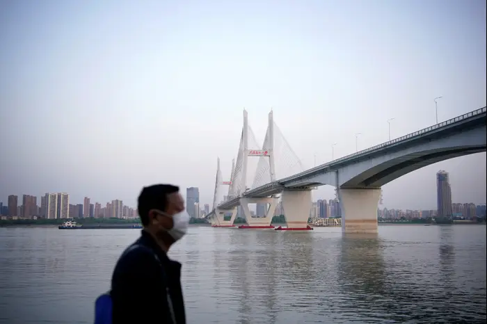 Un homme portant un masque pour défendre le virus Corona près du pont Yangtze à Wuhan, Chine 15 avril 2020 (Reuters)