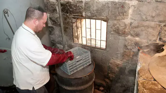 הגעלת כלים בתוך דודים ענקיים במקווה אורנשטיין בשכונת גאלה בירושלים, אפריל 2011