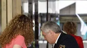 מאבטח בודק תיק בכניסה לקניון מאבטח בודק תיק בכניסה לקניון