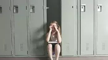 ילדה יושבת במסדרון בית ספר ילדה יושבת במסדרון בית ספר