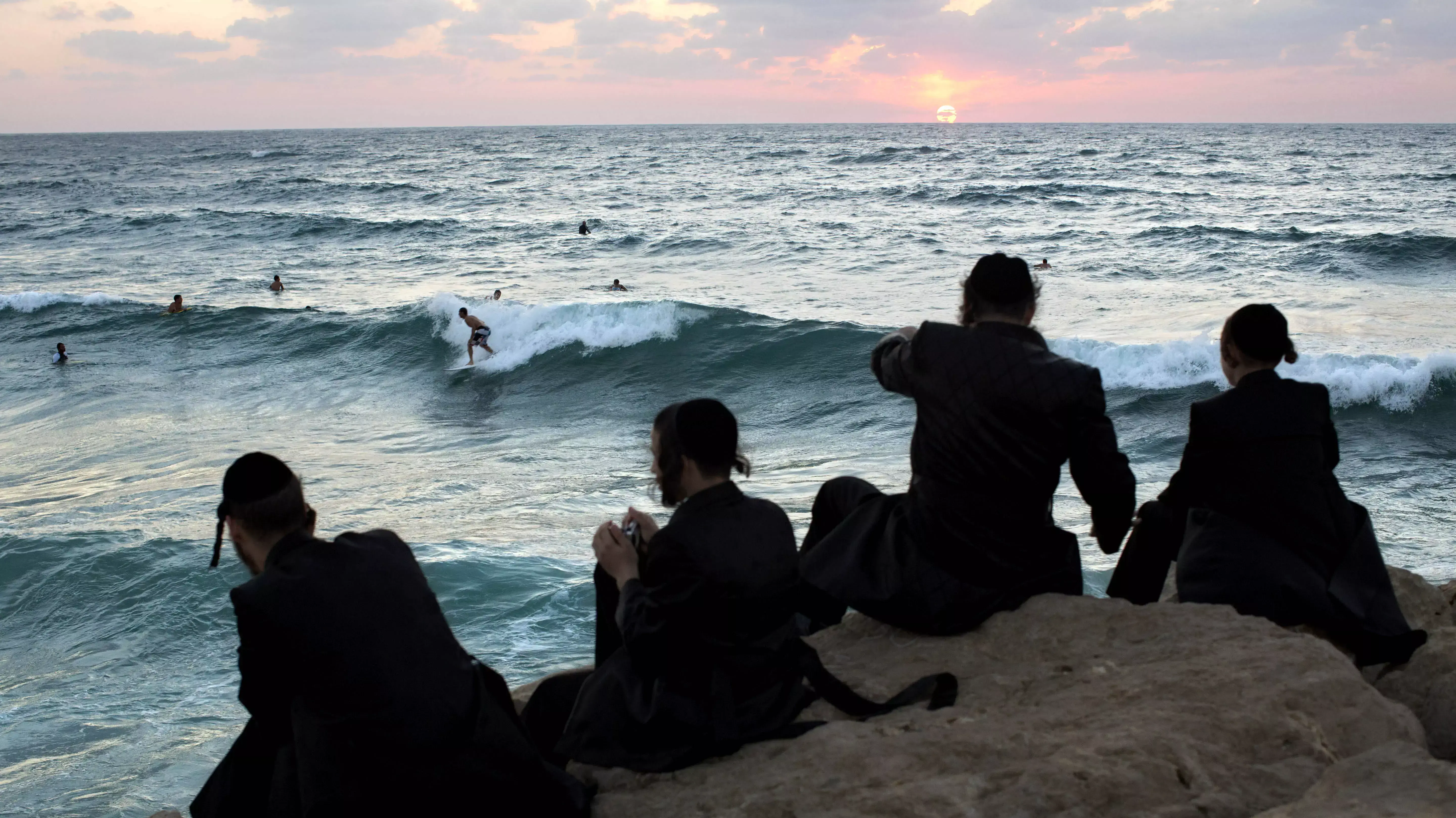 חרדים מביטים בגולשים בים באשדוד, ספטמבר 2013