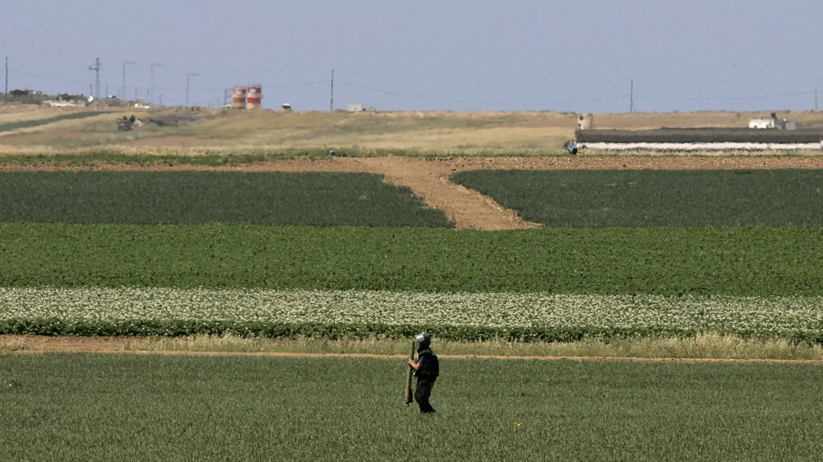 איש כוחות הביטחון מחזיק שרידי רקטה בשדות ליד קיבוץ נחל עוז, 2008 איש כוחות הביטחון מחזיק שרידי רקטה בשדות ליד קיבוץ נחל עוז, 2008