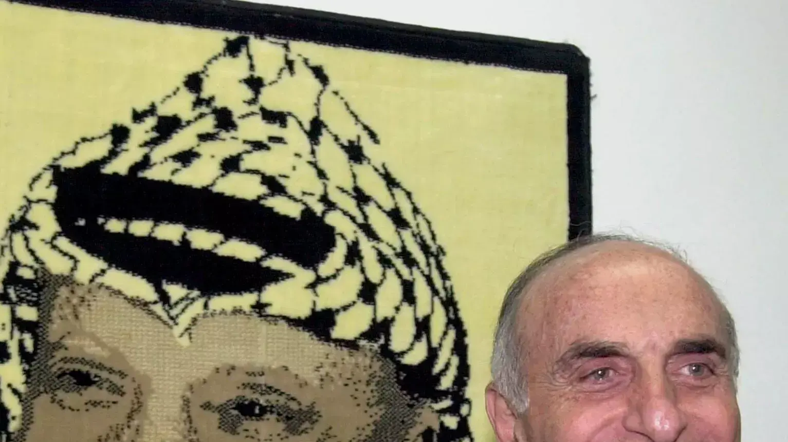 איש העסקים הפלסטיני מוניב אל מסרי ברקע תמונה של יאסר ערפאת איש העסקים הפלסטיני מוניב אל מסרי ברקע תמונה של יאסר ערפאת