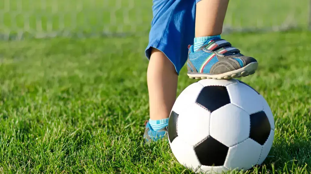 ילד משחק כדורגל ילד משחק כדורגל