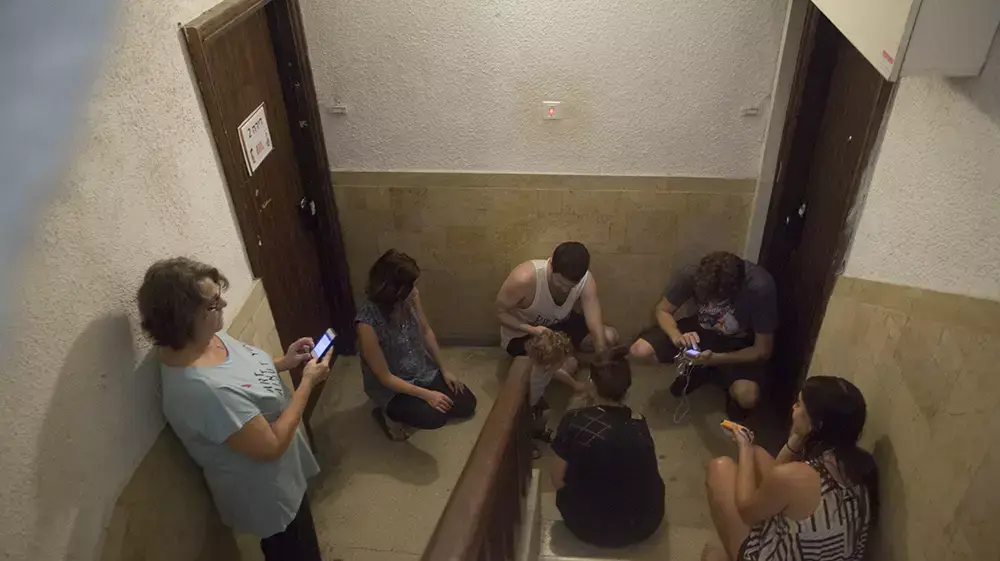 חדר מדרגות בבניין בתל אביב במהלך אזעקה, יולי 2014 חדר מדרגות בבניין בתל אביב במהלך אזעקה, יולי 2014