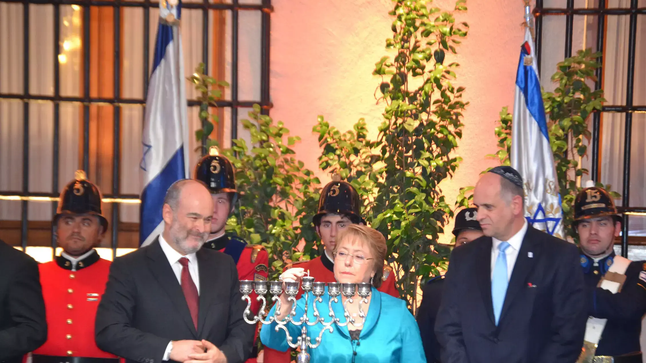 "נשיאת צ'ילה מישל באשלה מדליקה נרות יחד עם ראש הקהילה היהודית והשגריר רפאל אלדד" "נשיאת צ'ילה מישל באשלה מדליקה נרות יחד עם ראש הקהילה היהודית והשגריר רפאל אלדד"