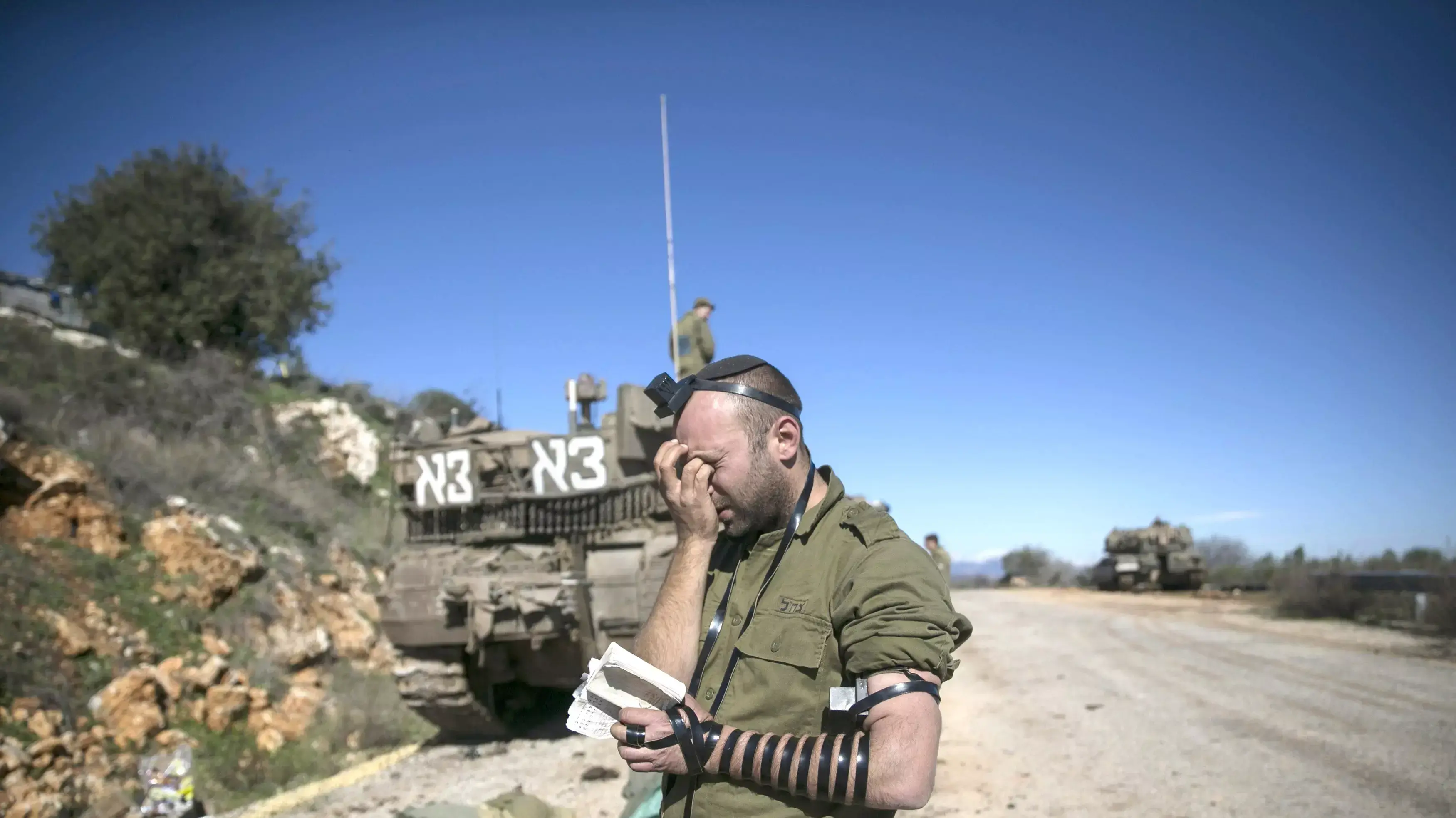 חייל ישראלי מתפלל ליד טנק בסמוך לגבול של ישראל עם לבנון, ינואר 2015