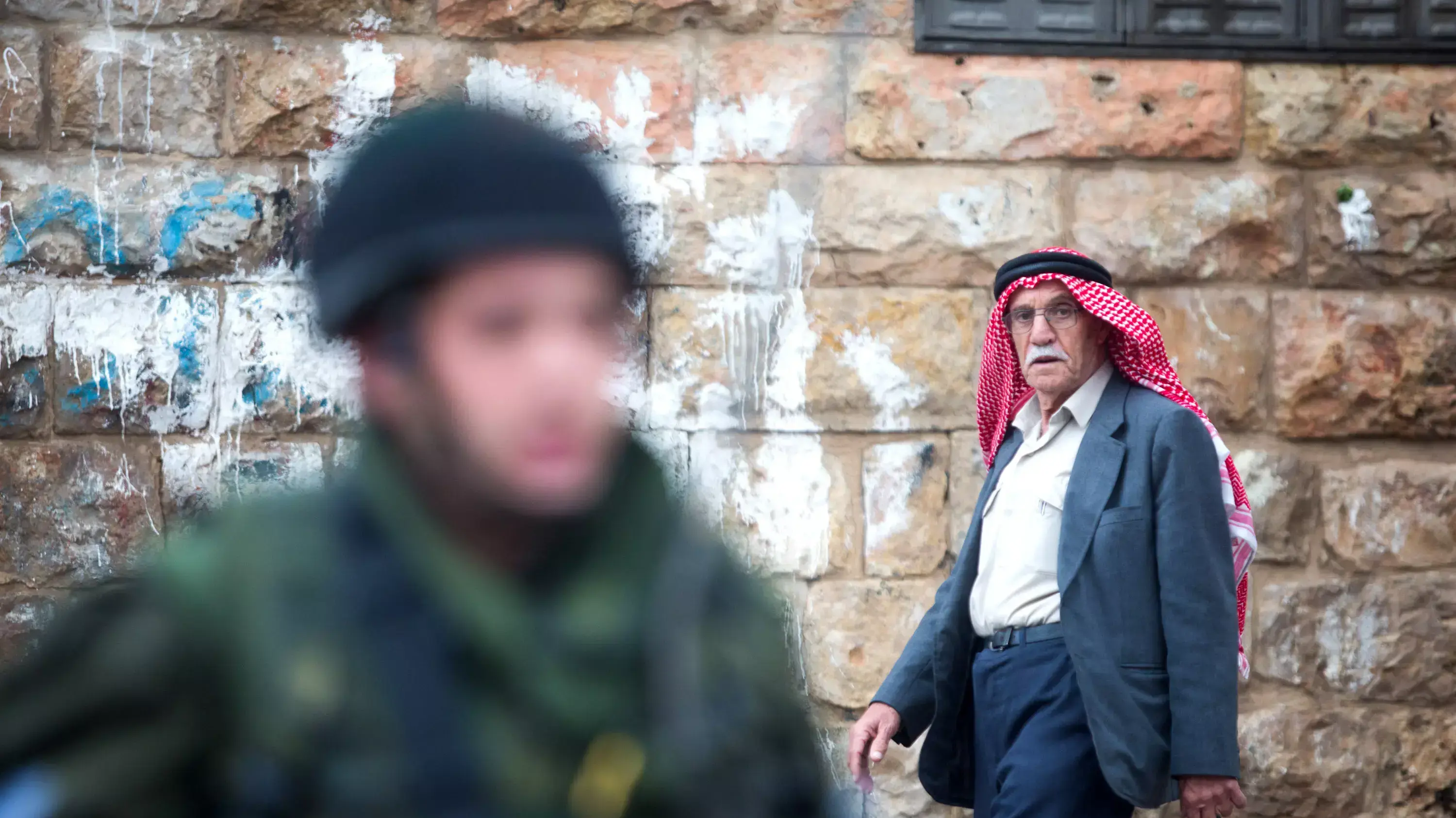 פלסטיני הולך ליד חייל צה"ל בעיר חברון פלסטיני הולך ליד חייל צה"ל בעיר חברון