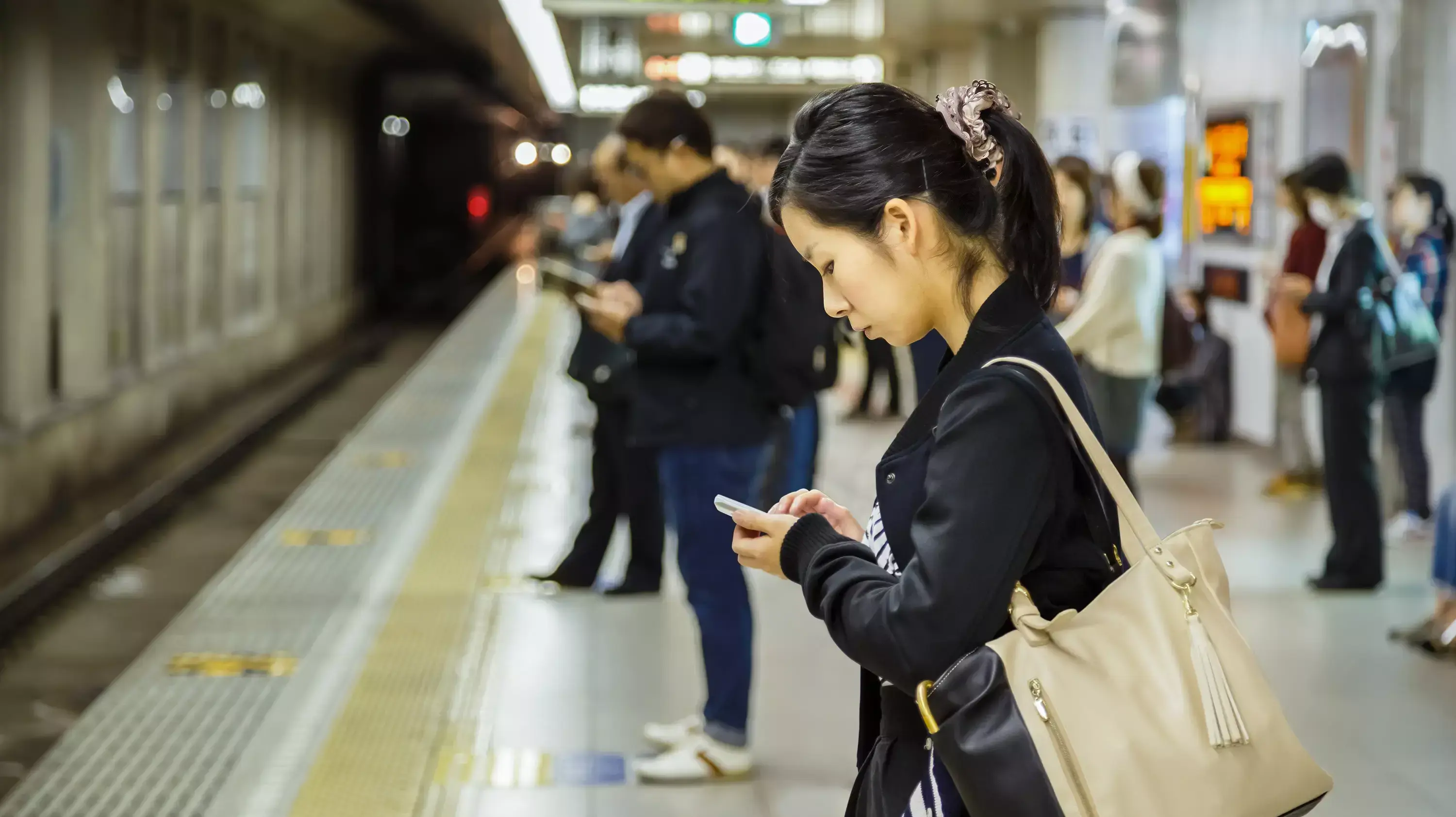 צעירה יפנית ממתינה ברציף רכבת תחתית בקיוטו יפן צעירה יפנית ממתינה ברציף רכבת תחתית בקיוטו יפן