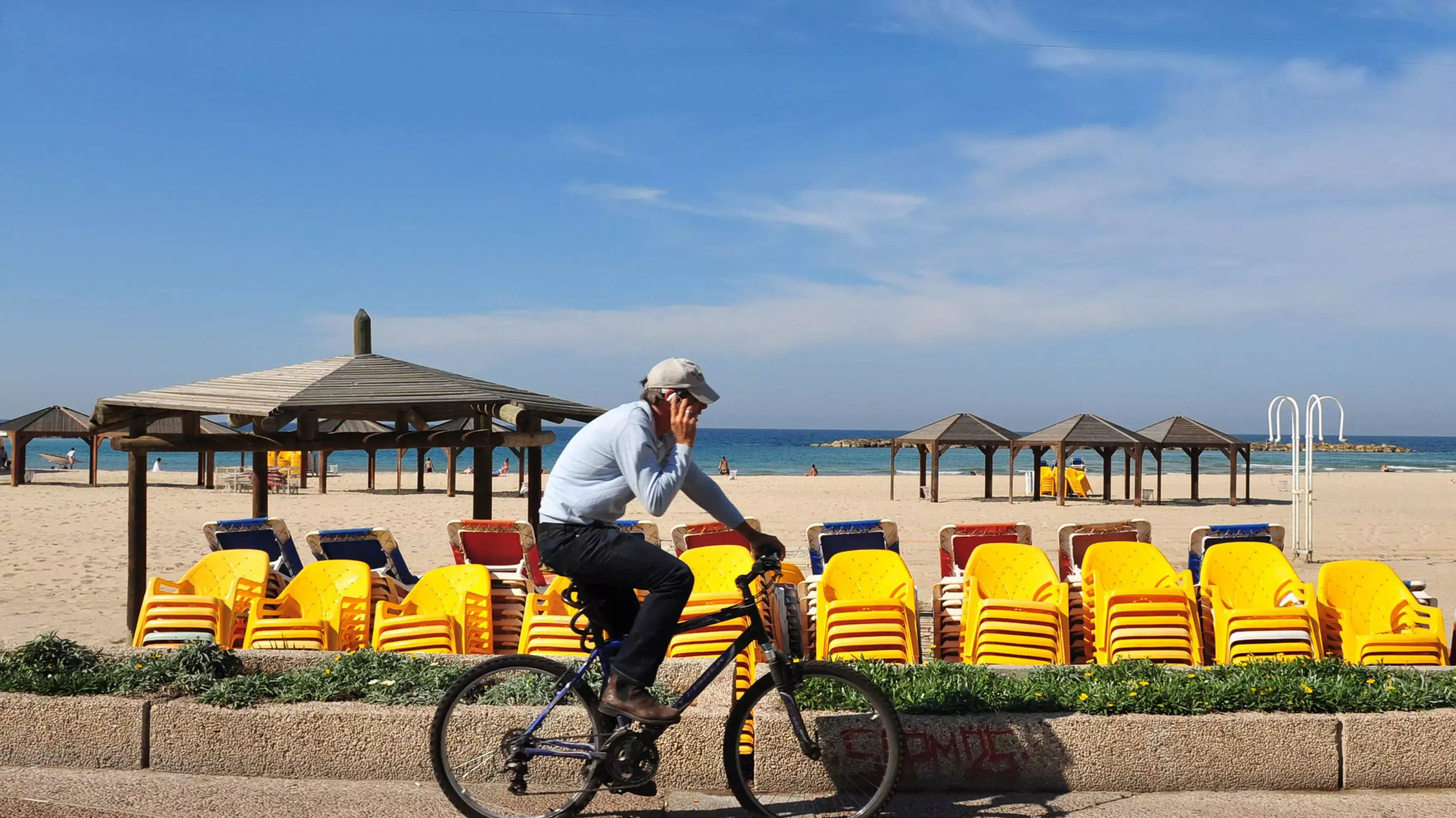 גבר רוכב על אופניים בטיילת בתל אביב גבר רוכב על אופניים בטיילת בתל אביב