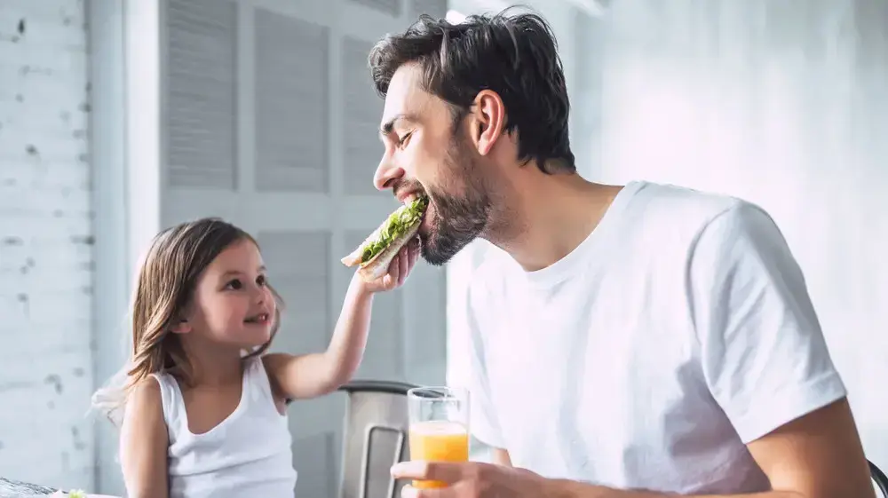 אבא וילדה אוכלים ארוחת בוקר אבא וילדה אוכלים ארוחת בוקר
