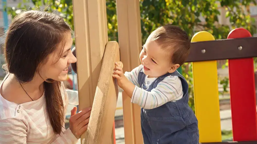 אמא ותינוק משחקים בגינת משחקים אמא ותינוק משחקים בגינת משחקים