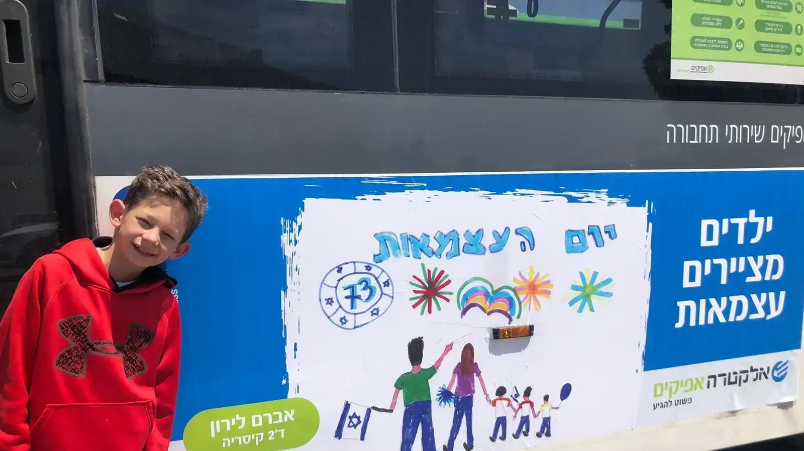 לירון אברם בן ה-10 ליד אוטובוס שקושט בציור שלו לירון אברם בן ה-10 ליד אוטובוס שקושט בציור שלו
