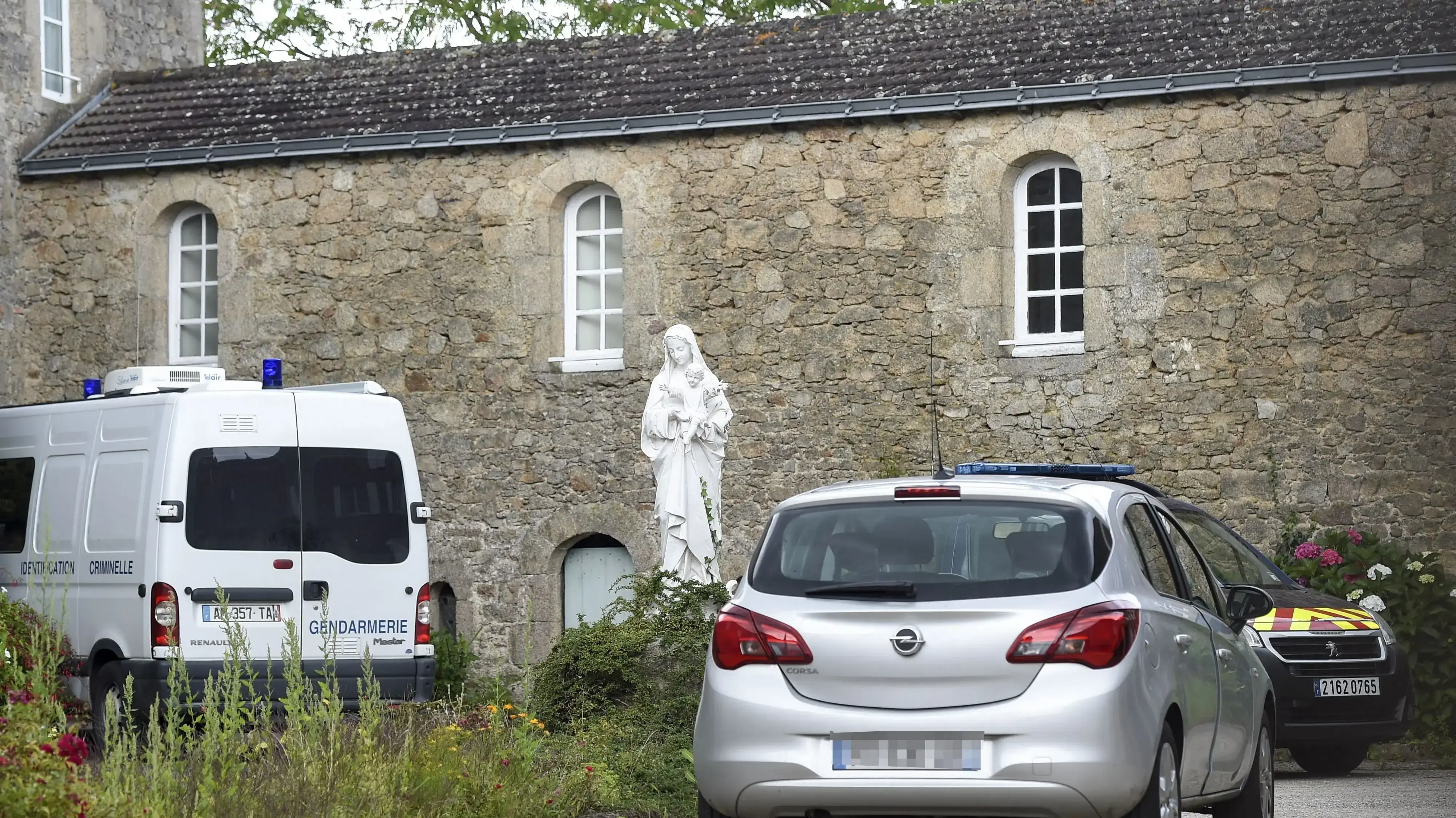 French gendarmerie vehicles are parked where a French catholic priest, aged 60, has been murdered in Saint-Laurent-sur-Sevres, Western France, on August 9, 2021. - The murderer, a Rwandan refugee suspected of causing a major fire that ravaged the cathedral in the French city of Nantes in 2020 and who had been welcome into his church by the priest for several months, was already under judicial control over the fire at Nantes cathedral in July 2020, the Interior minister and a source close to the French gendarmerie vehicles are parked where a French catholic priest, aged 60, has been murdered in Saint-Laurent-sur-Sevres, Western France, on August 9, 2021. - The murderer, a Rwandan refugee suspected of causing a major fire that ravaged the cathedral in the French city of Nantes in 2020 and who had been welcome into his church by the priest for several months, was already under judicial control over the fire at Nantes cathedral in July 2020, the Interior minister and a source close to the