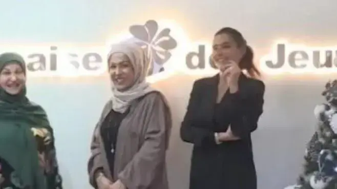 אישה שזכתה בפרס הראשון בלוטו בלבנון עומדת לצד הסכום שתקבל, דצמבר 2022
