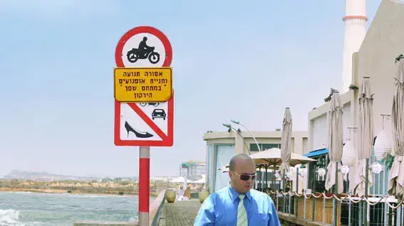 שלט על טיילת נמל תל אביב האוסר הליכה עם נעל עקב שלט על טיילת נמל תל אביב האוסר הליכה עם נעל עקב