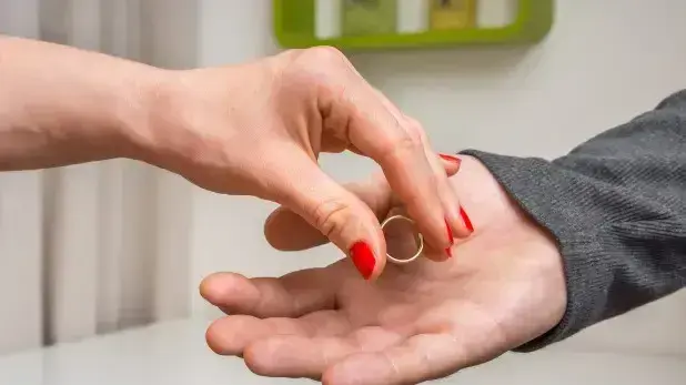 אשה מניחה טבעת נישואים ביד של גבר אשה מניחה טבעת נישואים ביד של גבר