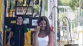 נערה משוחחת בסלולרי בתחנת דלק נערה משוחחת בסלולרי בתחנת דלק
