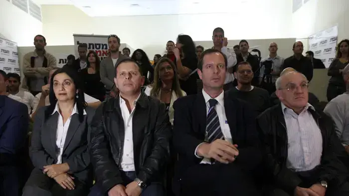 חברי מפלגת העבודה צופים בתשדירי בחירות
