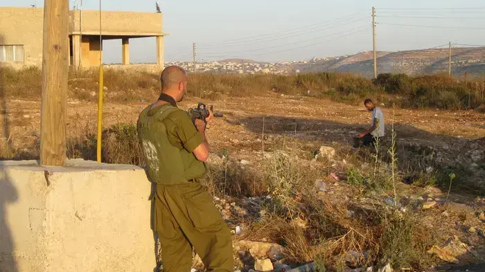 נהג הסעות פלסטיני מציג בפני חיילים במחסום את תיקיהם של הנוסעים לבדיקה נהג הסעות פלסטיני מציג בפני חיילים במחסום את תיקיהם של הנוסעים לבדיקה